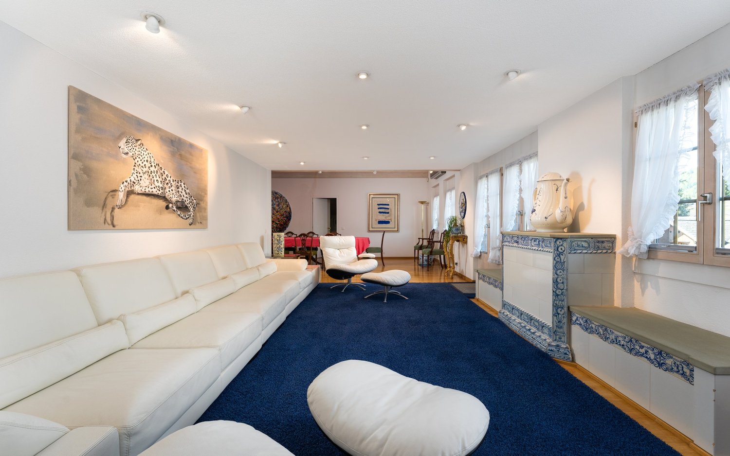 Helles Wohnzimmer mit blauem Teppich und langen Sitzbänken