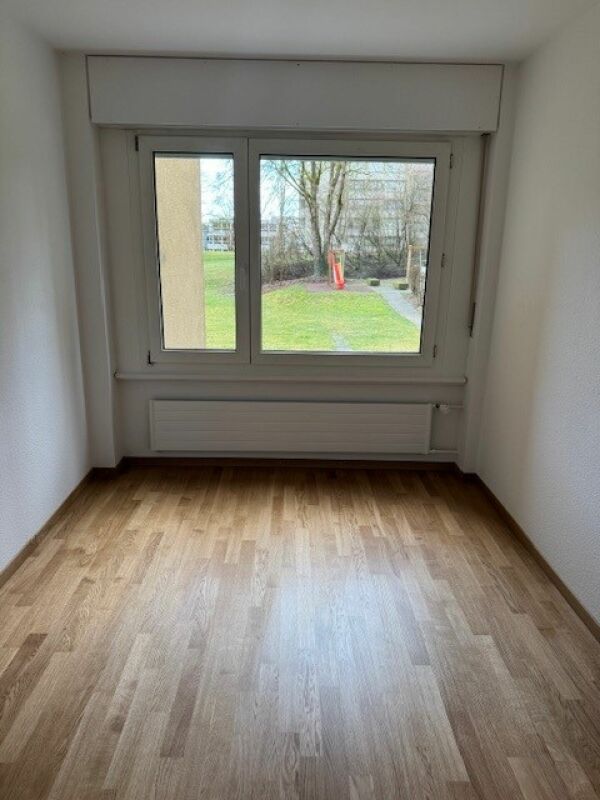 Leeres Zimmer mit Fenster und Parkettboden