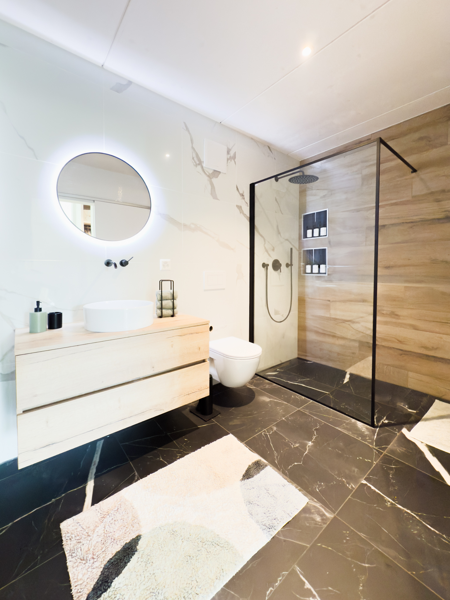Modernes Badezimmer mit Walk-in-Dusche und beleuchtetem Spiegel