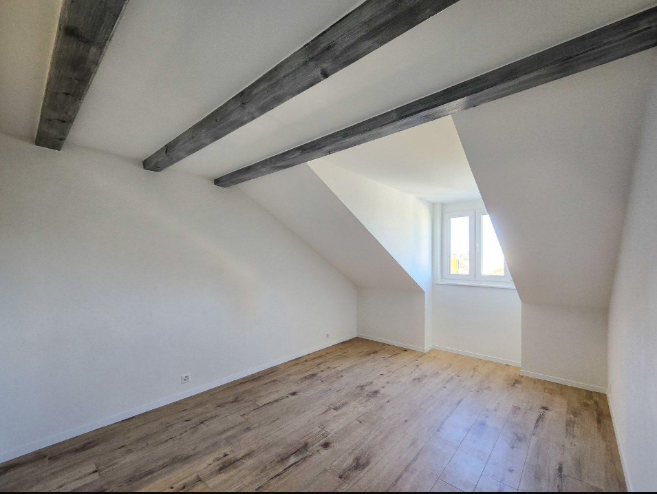 Dachgeschosszimmer mit sichtbaren Holzbalken