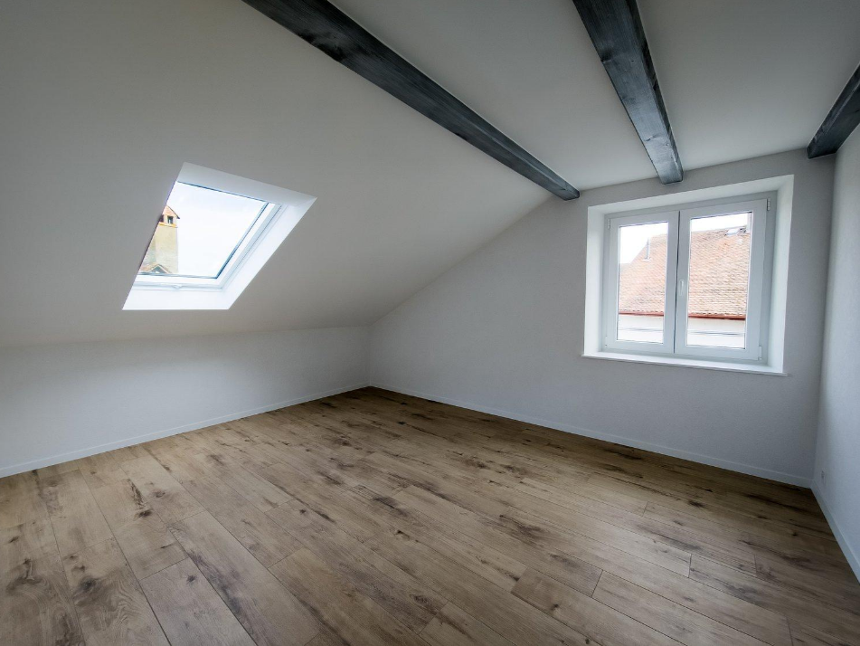 Dachzimmer mit Sichtbalken und Dachfenster