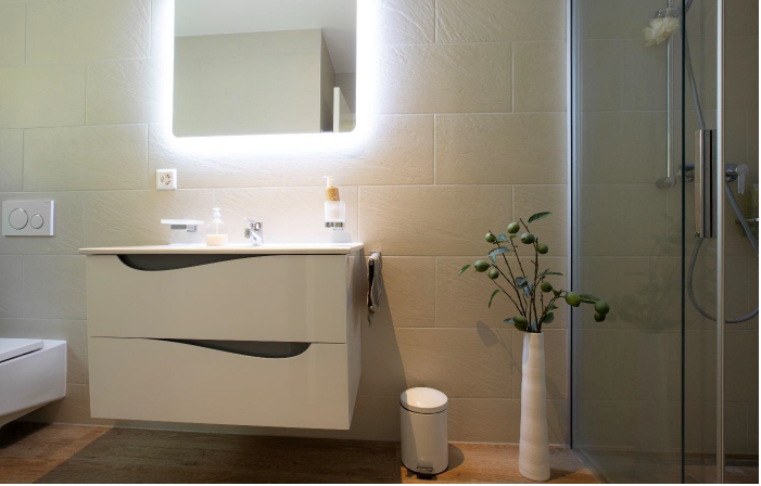 Modernes Badezimmer mit beleuchtetem Spiegel