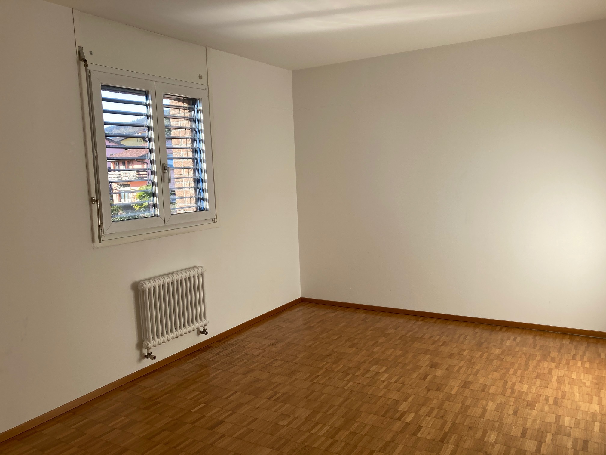 Leerer Wohnraum mit Fenster und Heizkörper