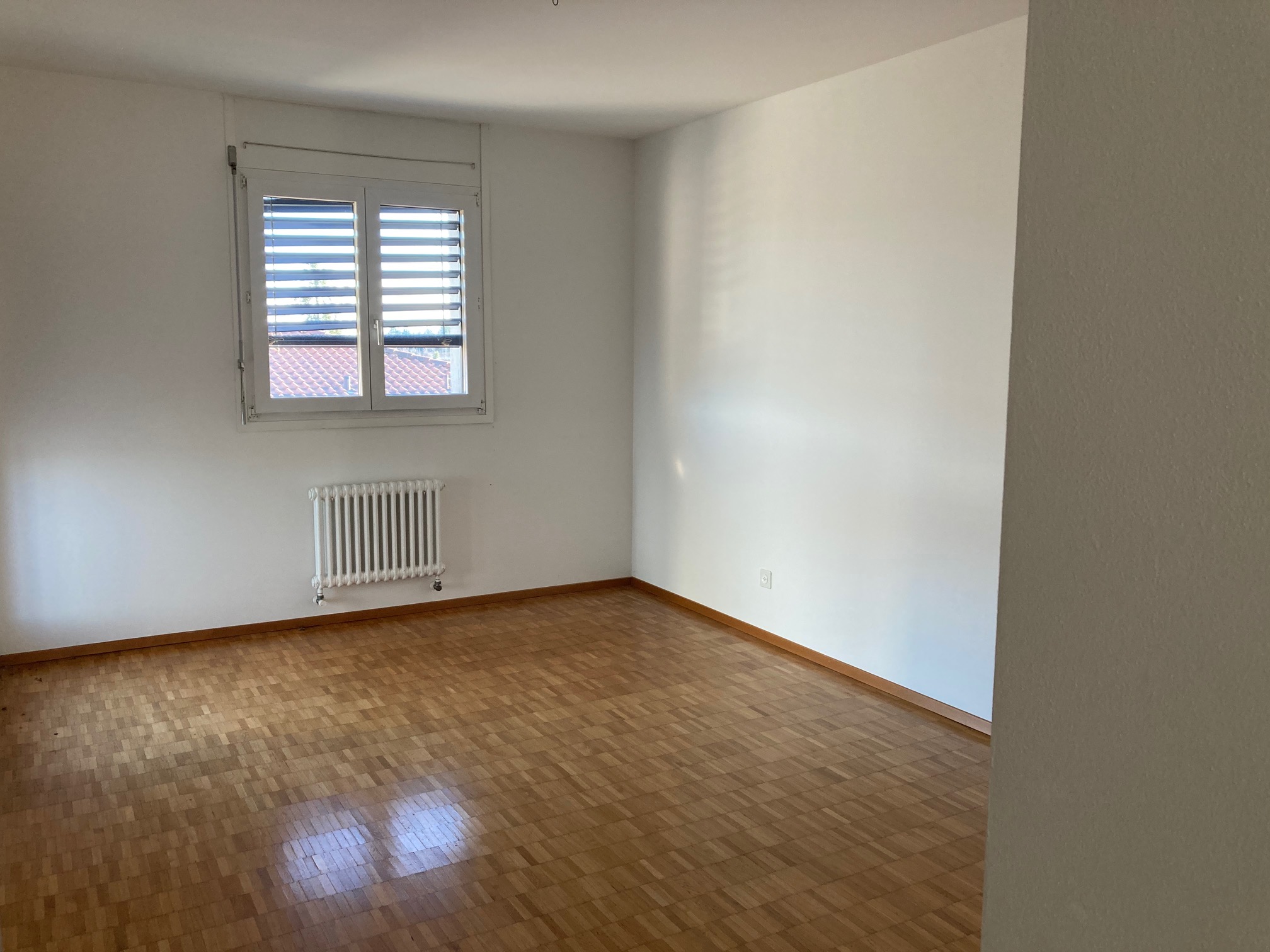 Leerer Raum mit Parkett und Fenster