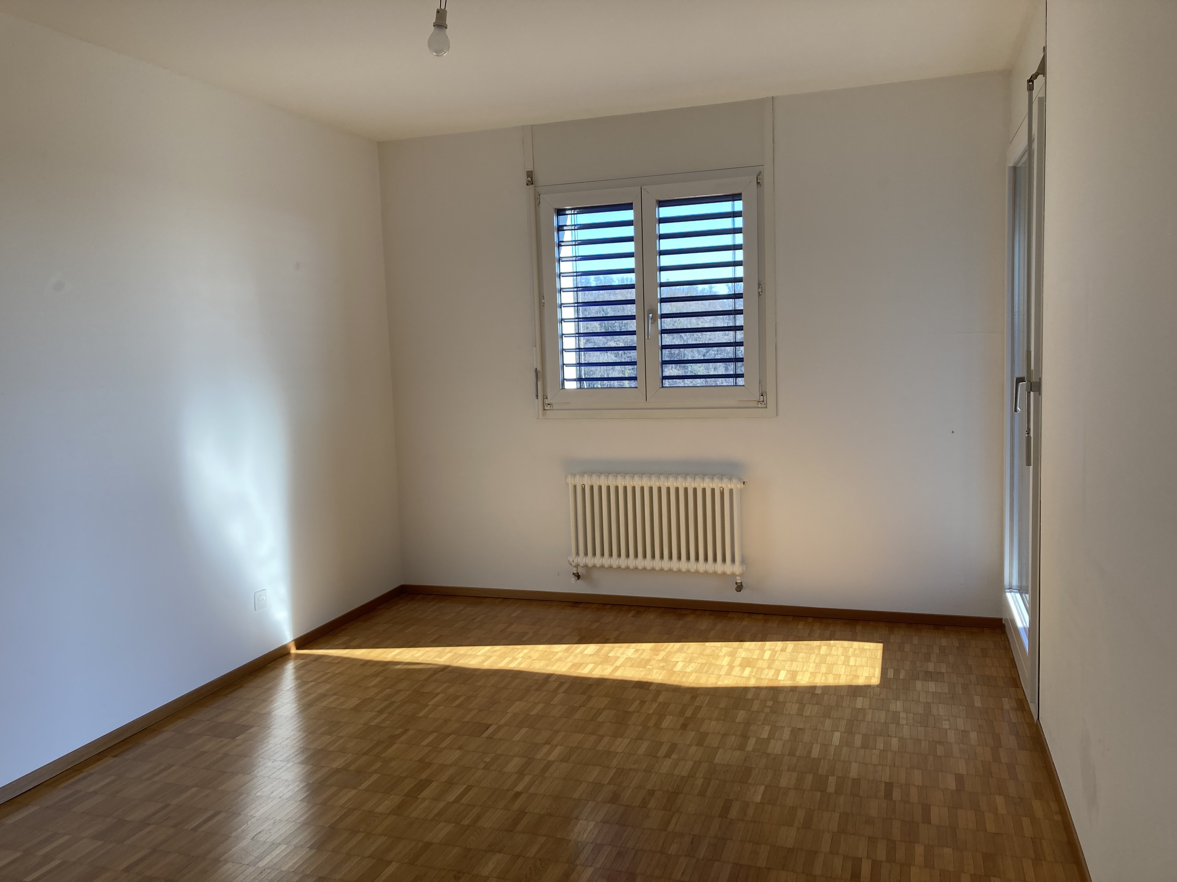 Leeres Zimmer mit Parkett und Fenster