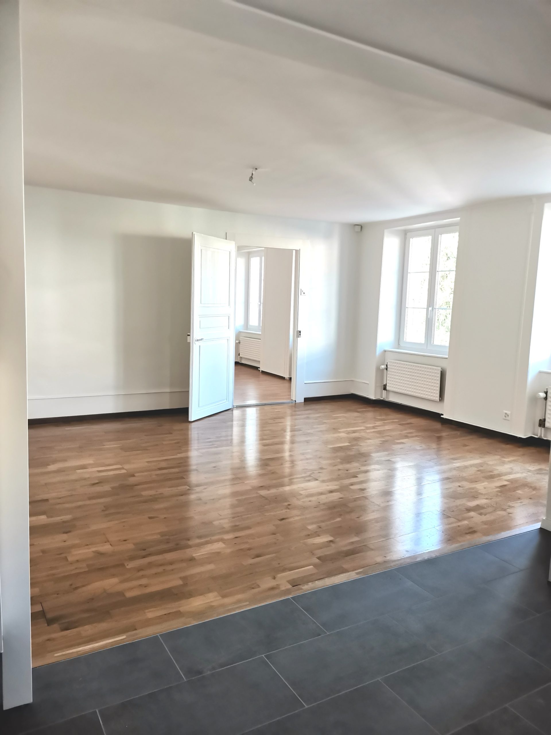 Heller leerer Raum mit Parkett und Fliesenbereich