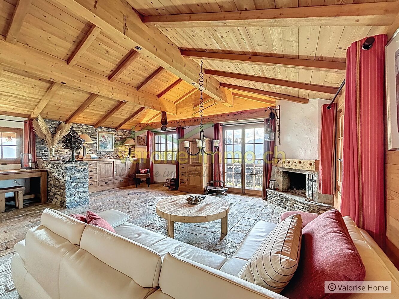 Rustikales Wohnzimmer mit Kamin und Holzbalkendecke