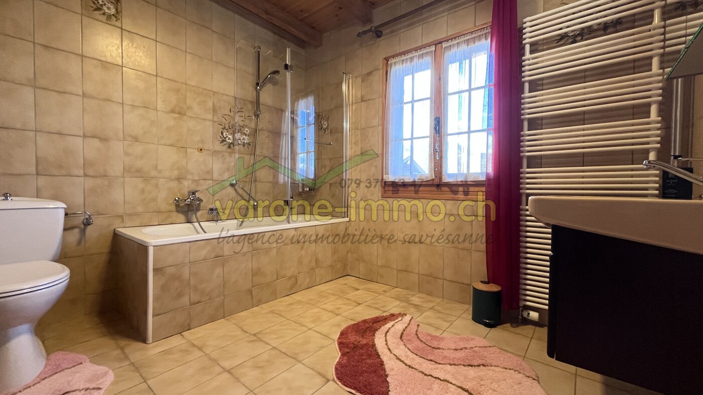 Rustikales Badezimmer mit Badewanne und Fenster