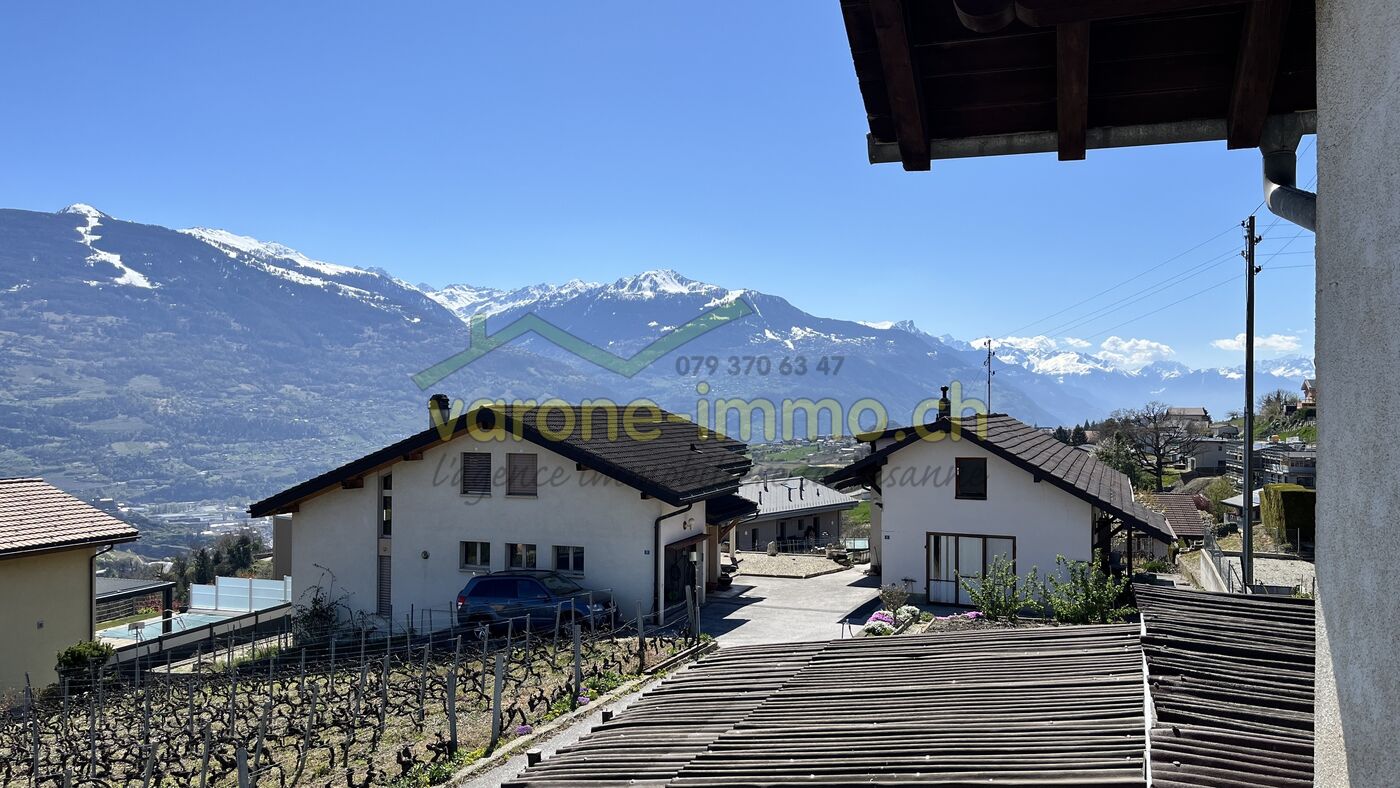 Alpenblick von einem Haus mit Garten und Nachbargebäuden