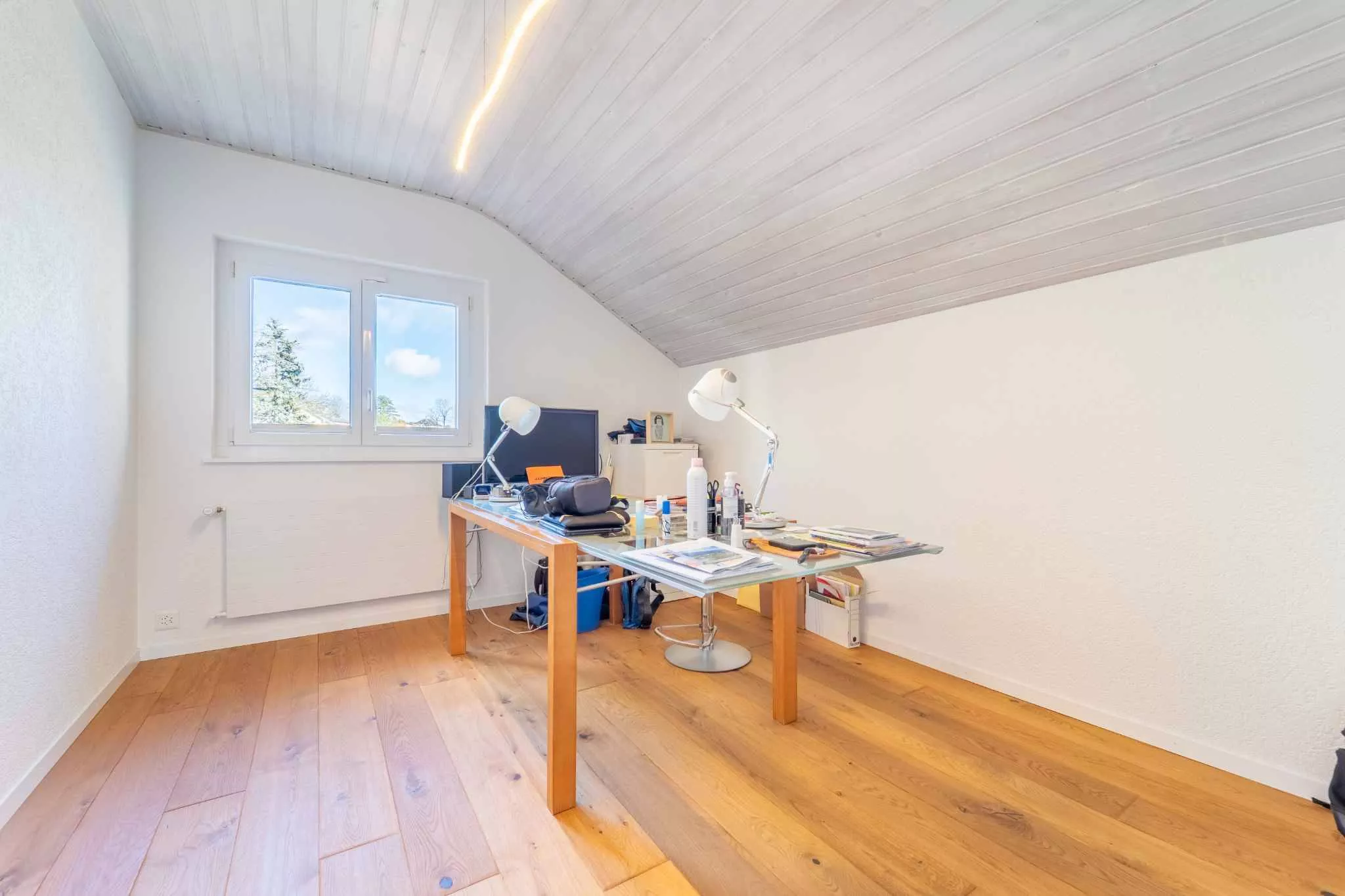 Helles Dachgeschoss-Büro mit Holztisch