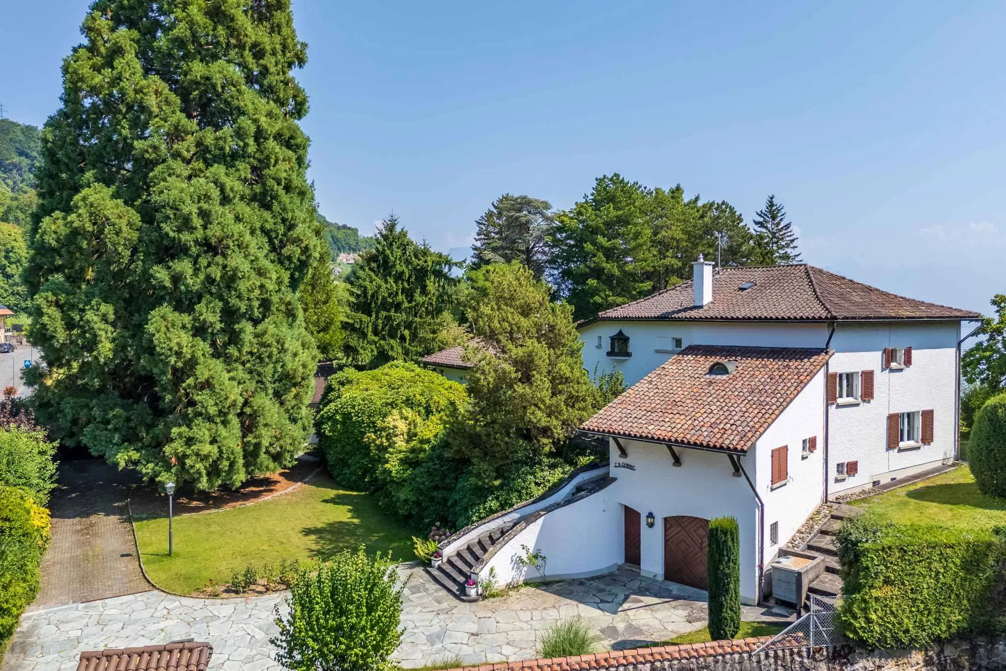 Villenansicht mit Garten und mediterranem Satteldach