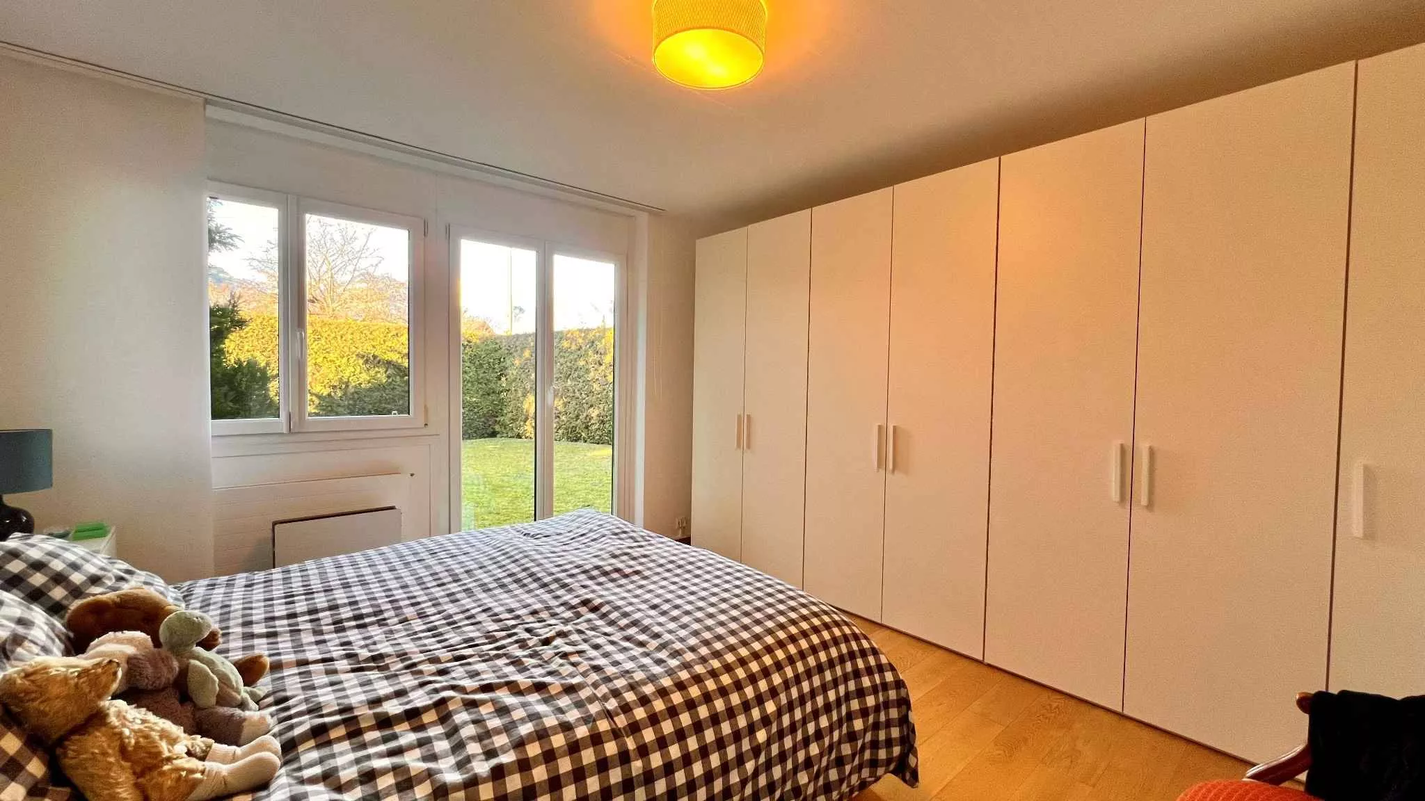 Helles Schlafzimmer mit Einbauschrank und Gartenblick