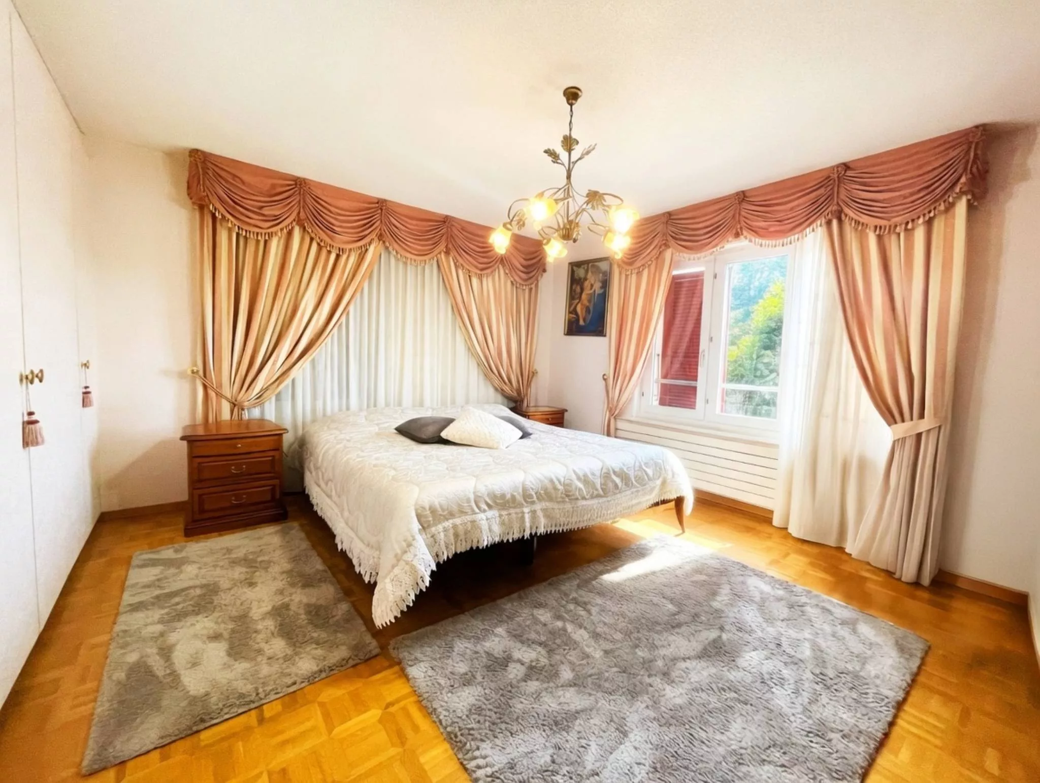 Klassisches Schlafzimmer mit Vorhängen und Kronleuchter