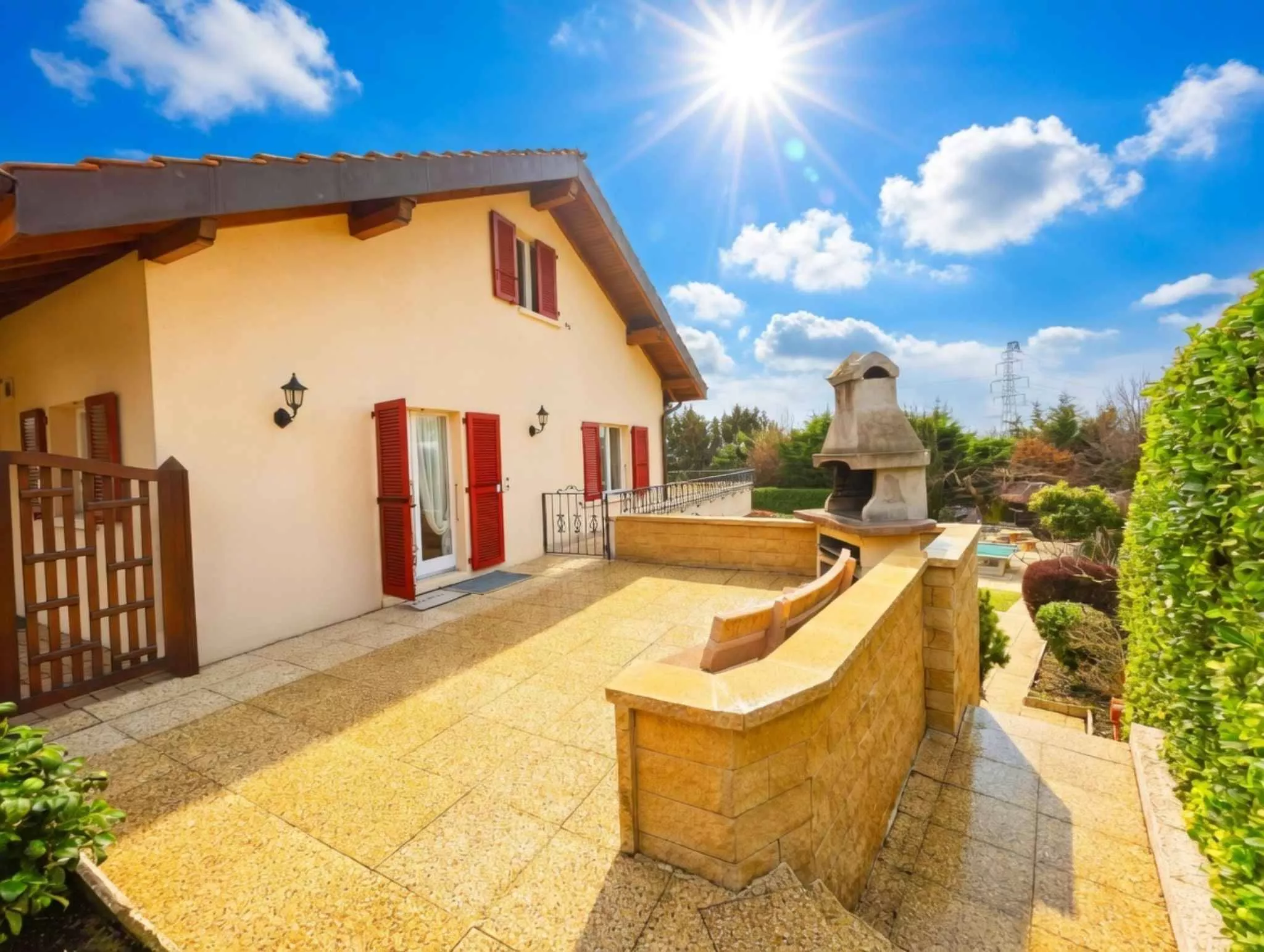 Außenansicht einer mediterranen Terrasse mit Haus und Grill