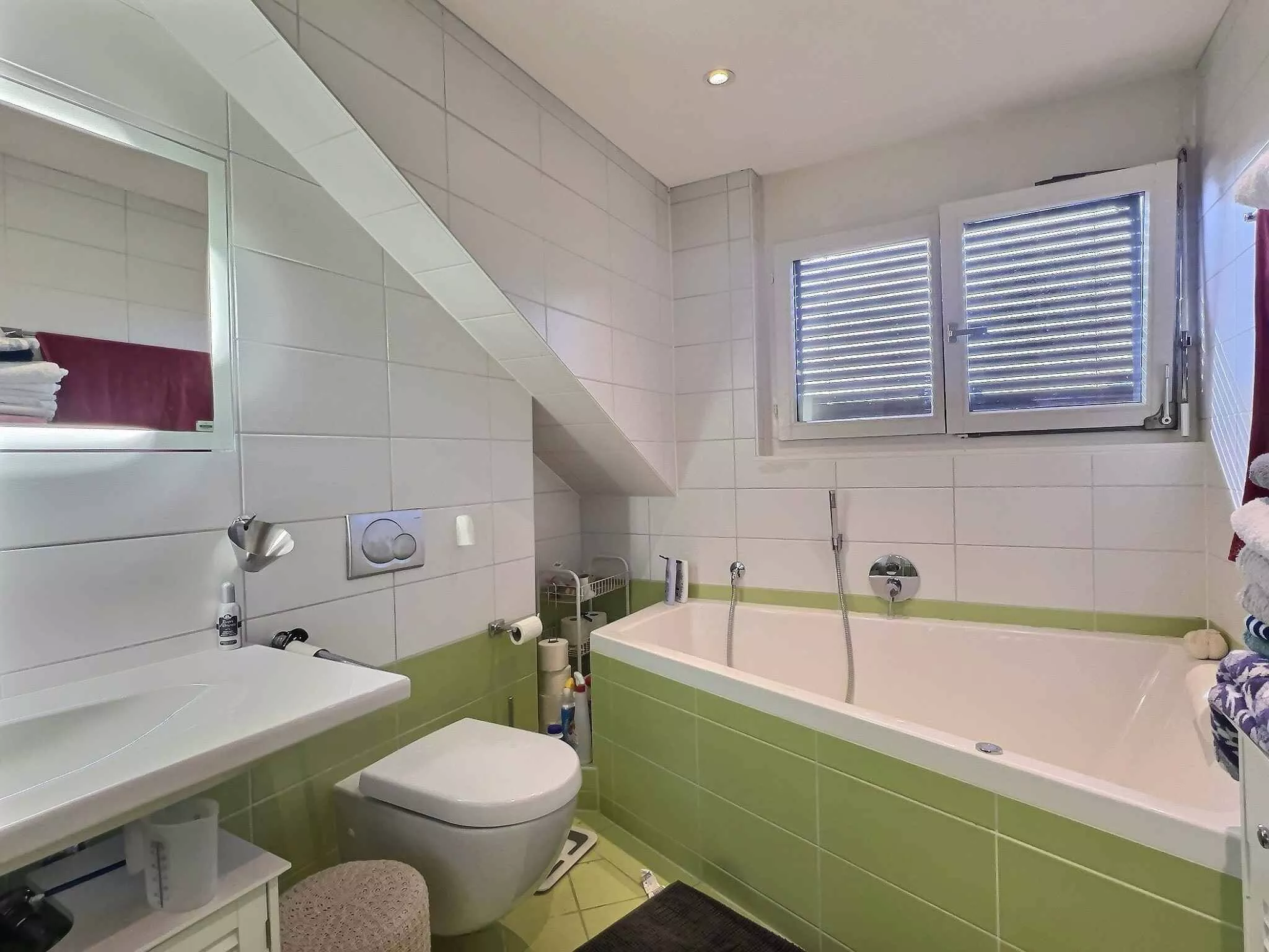 Helles Badezimmer mit Badewanne und Fenster