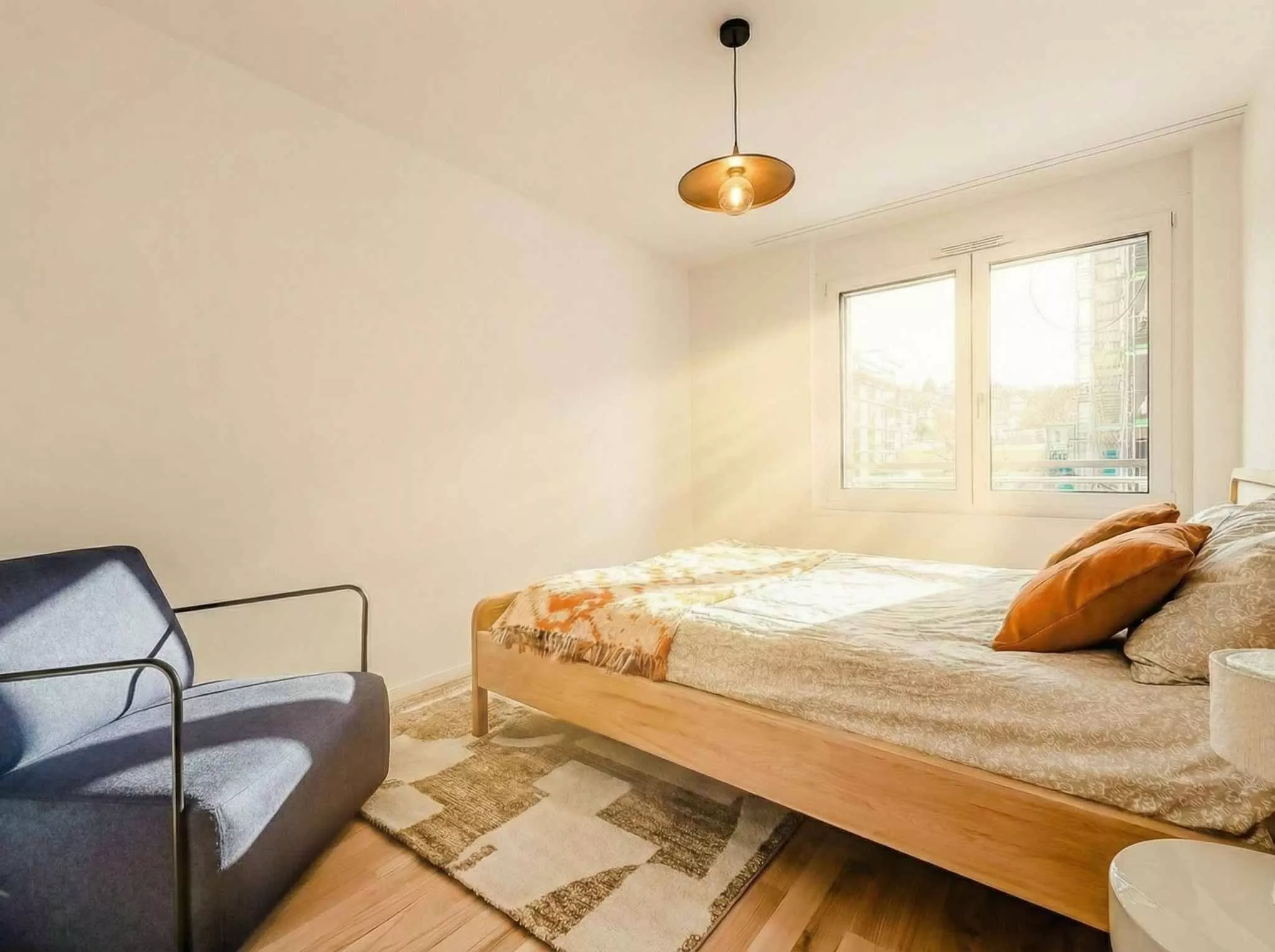 Helles Schlafzimmer mit schlichtem Holzbett
