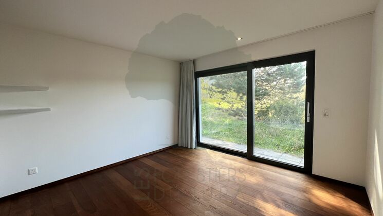Leeres Zimmer mit großer Schiebetür zum Garten