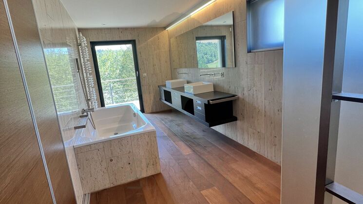 Modernes Badezimmer mit Natursteinoptik und Holzfußboden