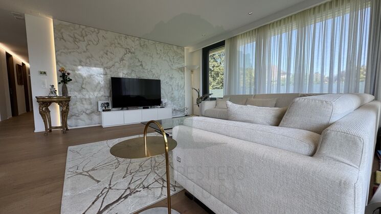 Modernes Wohnzimmer mit großem Sofa und Marmorkaminwand