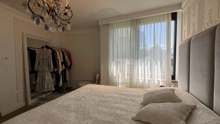 Elegantes Schlafzimmer mit großem Fenster und Ankleidebereich