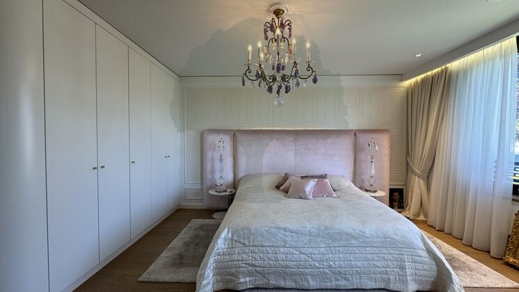 Elegantes Schlafzimmer mit Wandkleiderschrank und Kronleuchter