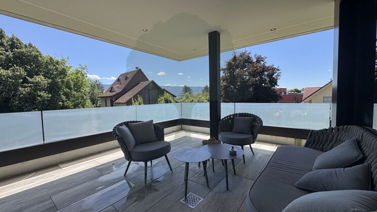 Überdachte Terrasse mit Lounge-Möbeln und Panoramablick