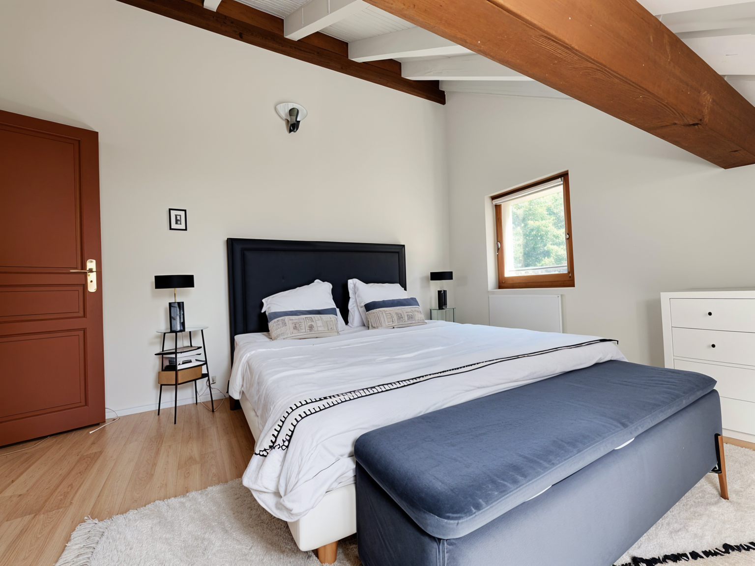 Helles Schlafzimmer mit sichtbaren Holzbalken
