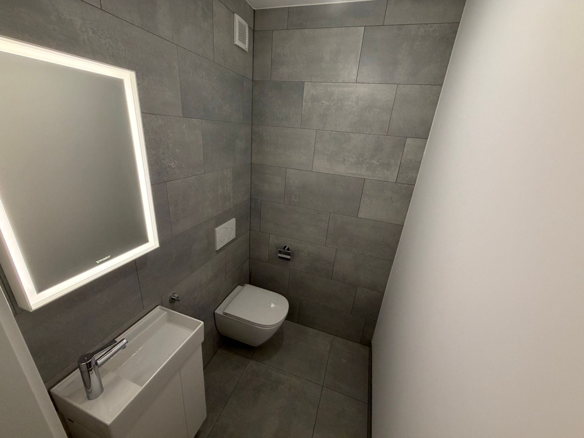 Modernes Gäste-WC mit Spiegel und wandhängendem WC