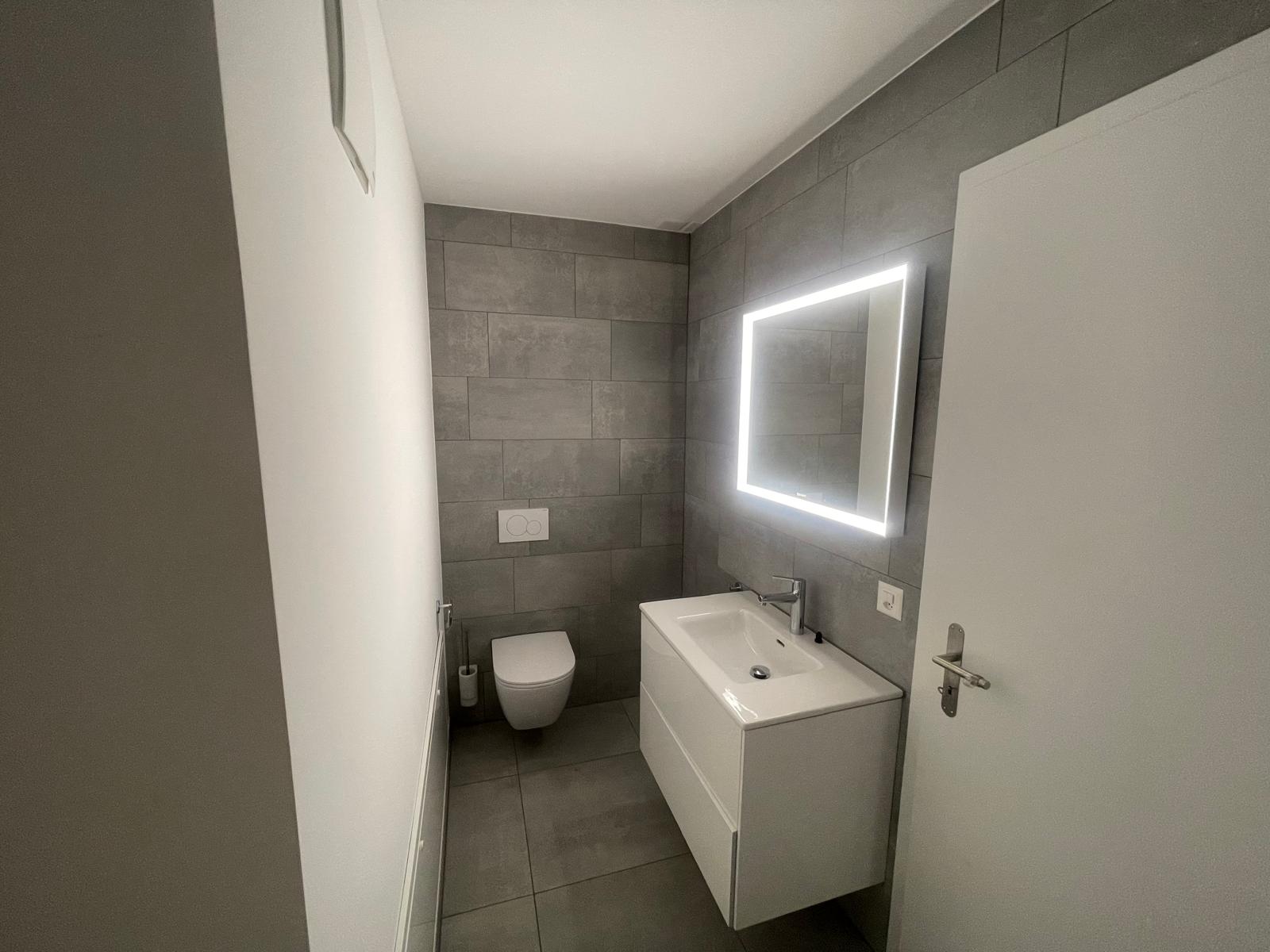 Modernes Gäste-WC mit LED-Spiegel