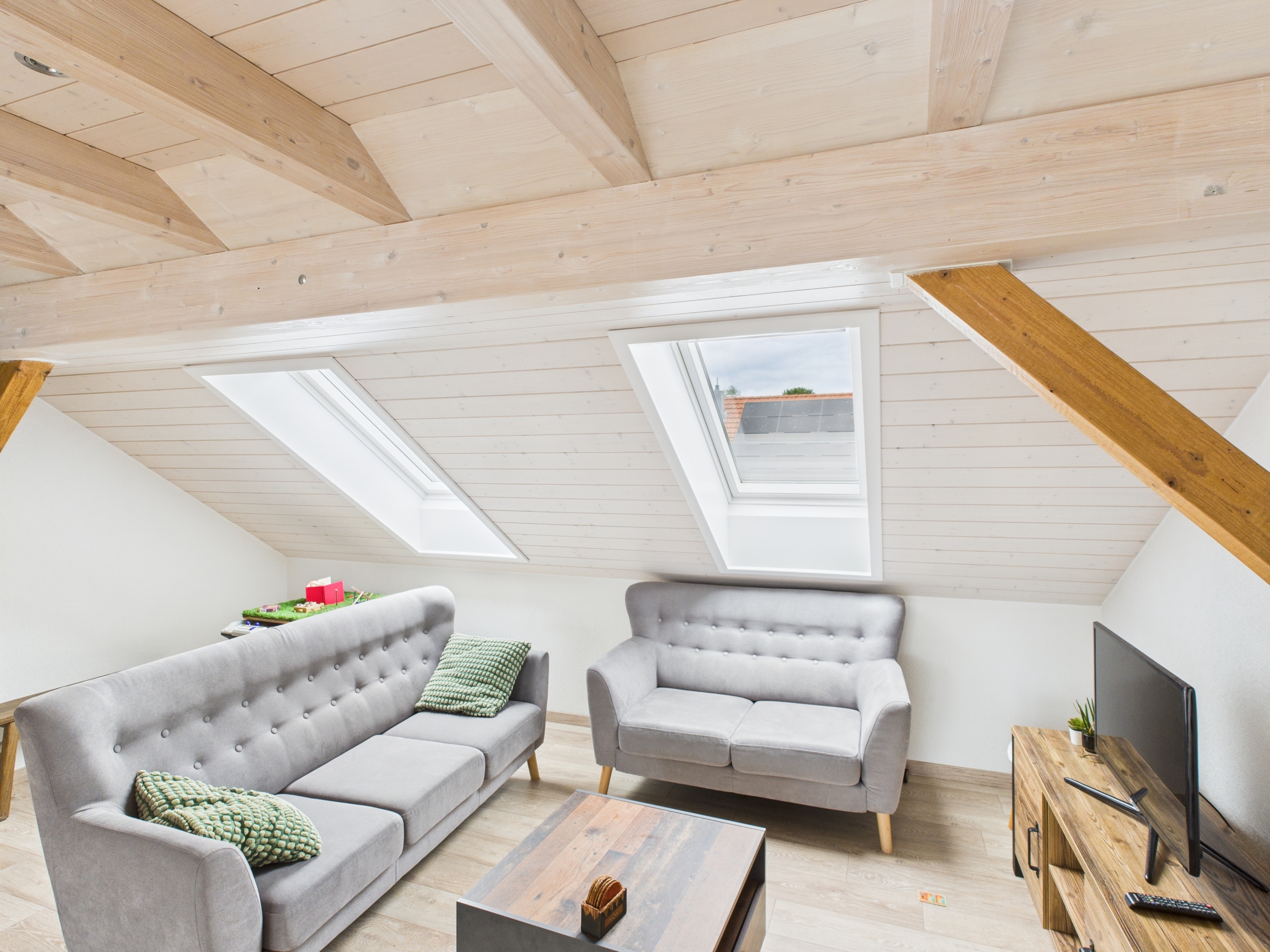 Dachgeschoss-Wohnzimmer mit sichtbaren Holzbalken