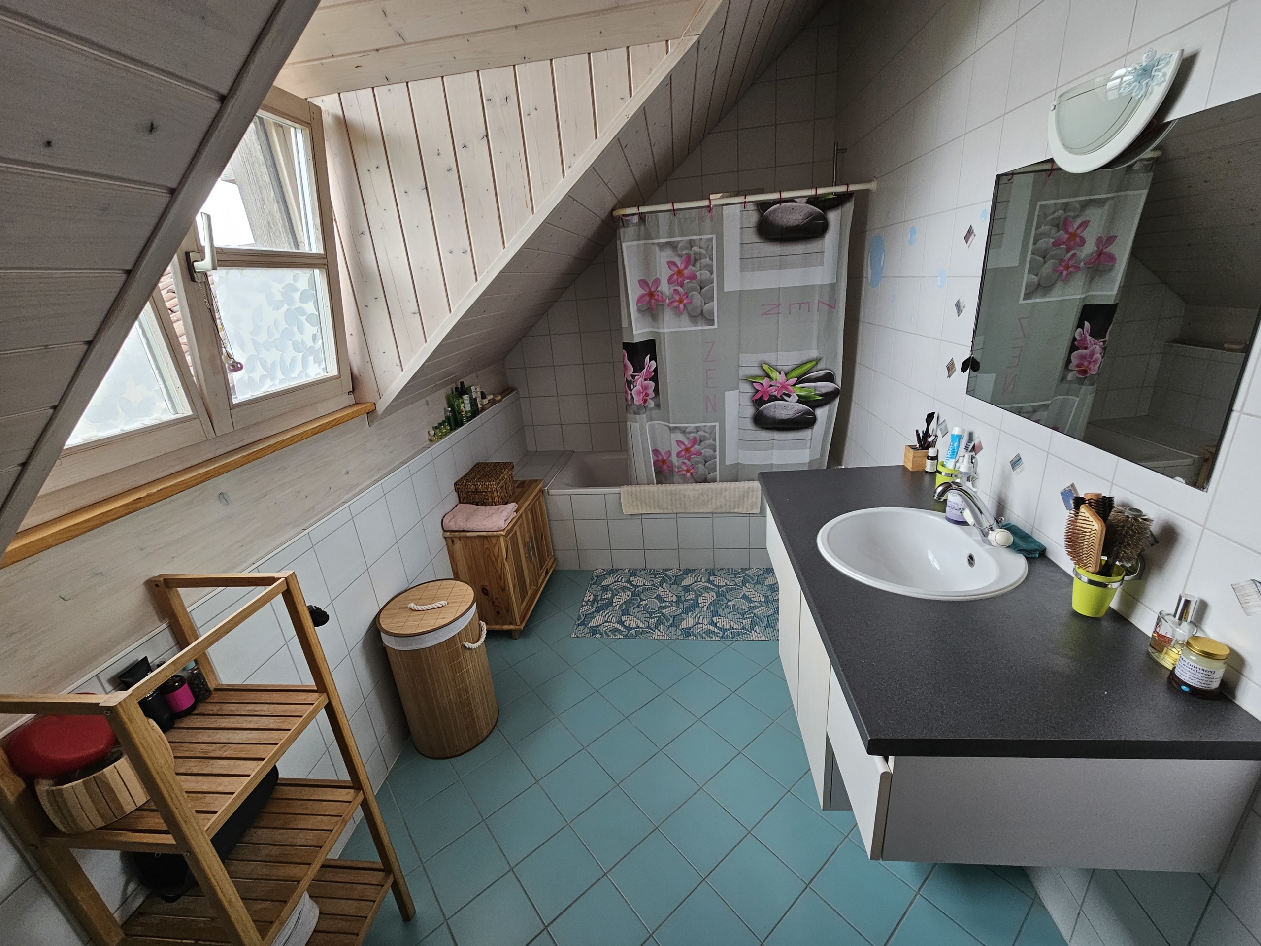 Dachgeschoss-Badezimmer mit Badewanne und Waschtisch