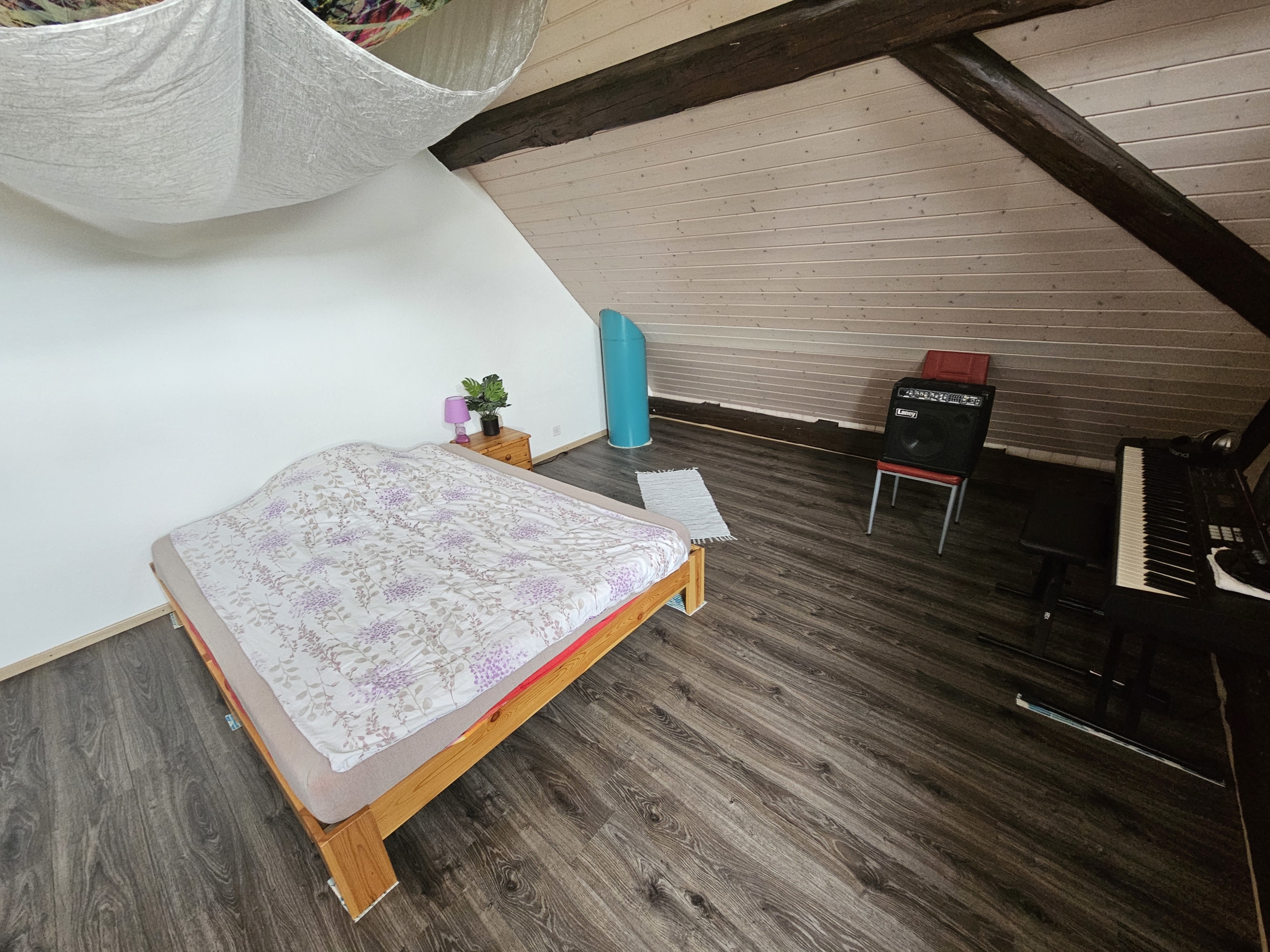 Dachzimmer mit Bett und Musikecke