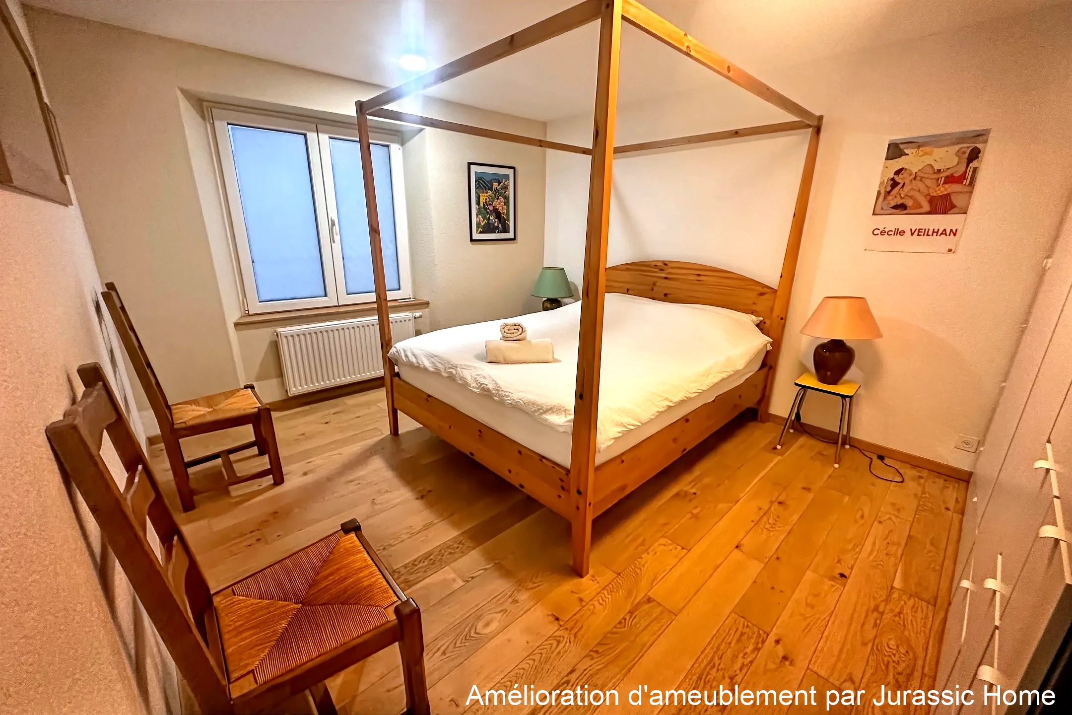 Schlafzimmer mit Holzbett und zwei Stühlen