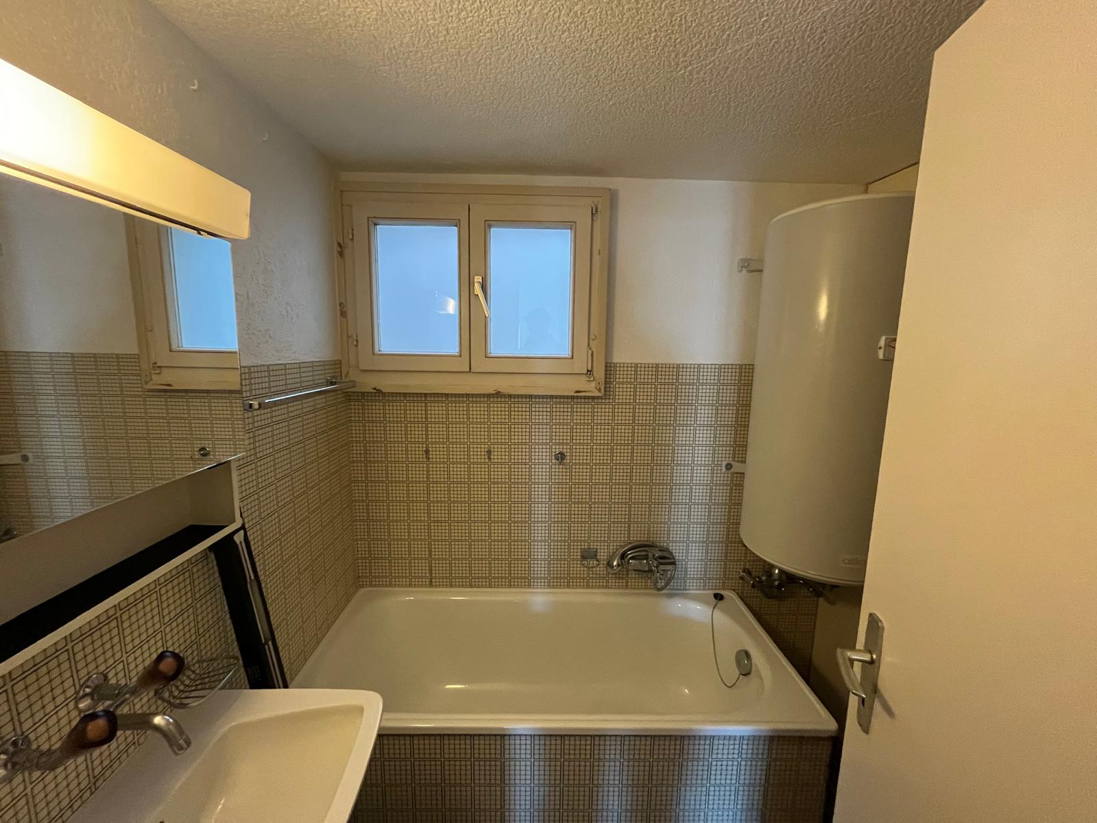 Kleines Bad mit Badewanne und Waschtisch