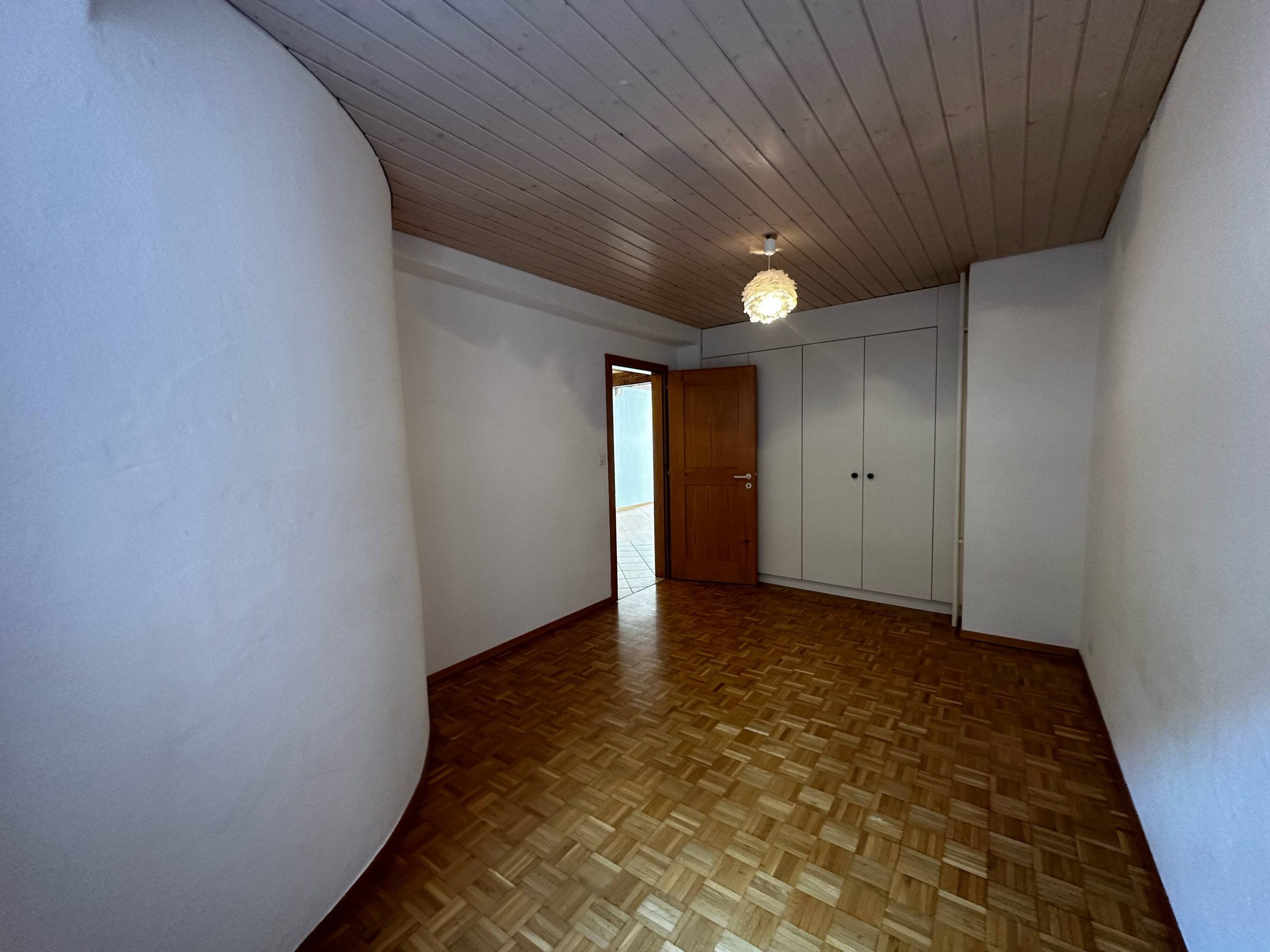 Helles Zimmer mit Holzdecke und Einbauschrank