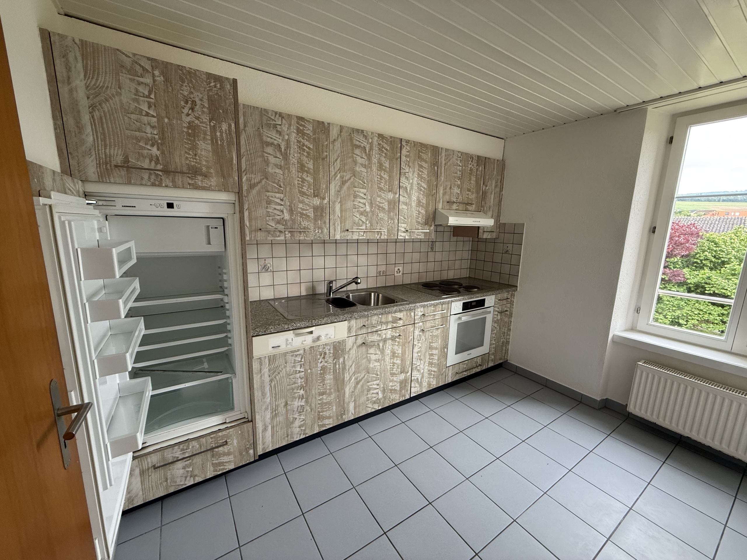 Kleine Küche mit Fenster und hellem Tageslicht