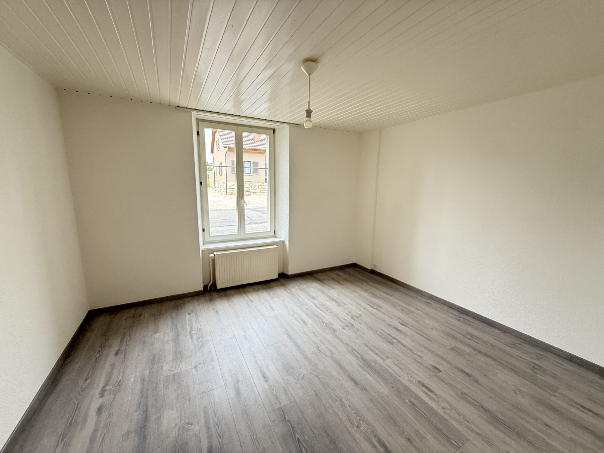 Leerer heller Raum mit Fenster und Heizkörper