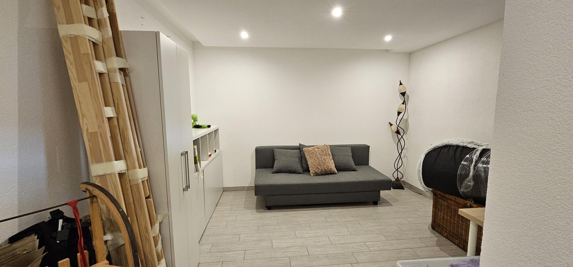 Kleiner wohnlicher Raum mit Sofa und Stauraum