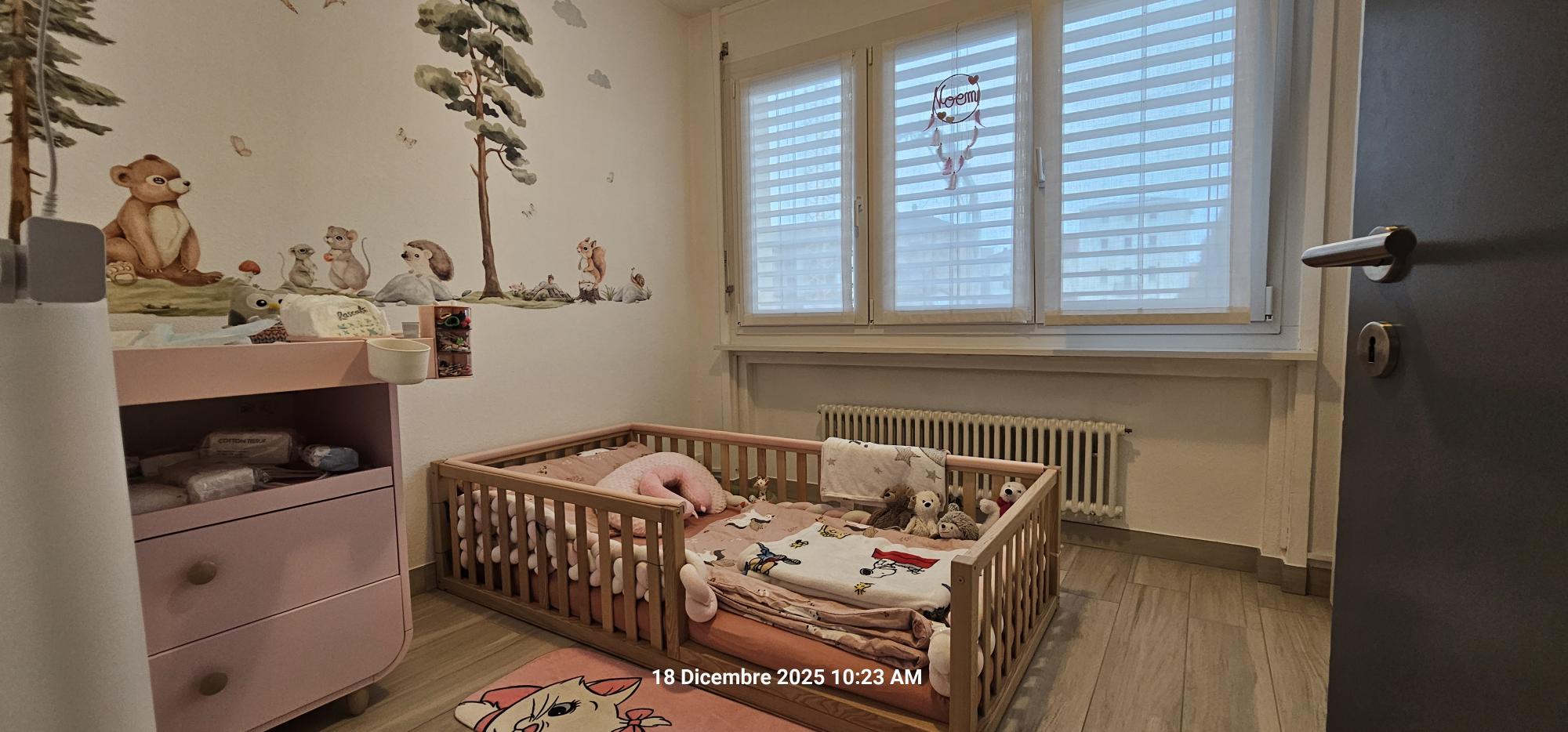 Kinderzimmer mit Gitterbett und Fenster