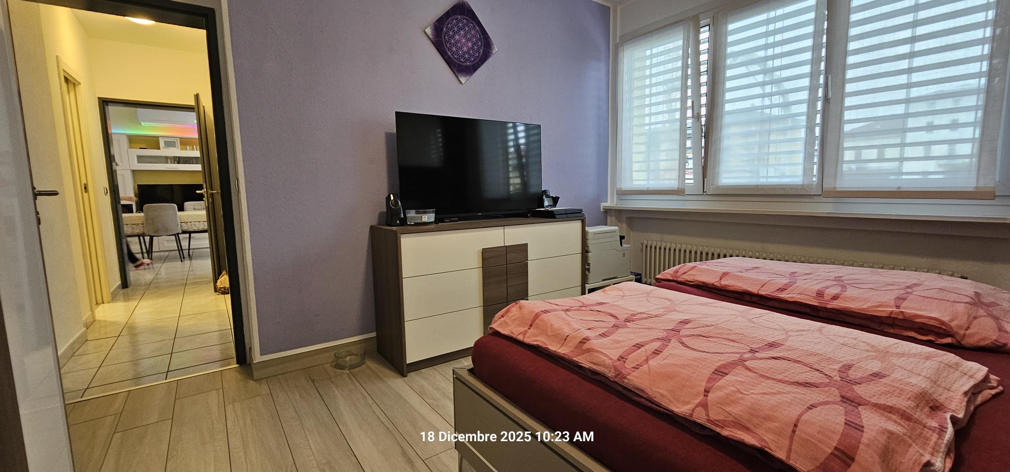 Schlafzimmer mit Doppelbett und Fernseher