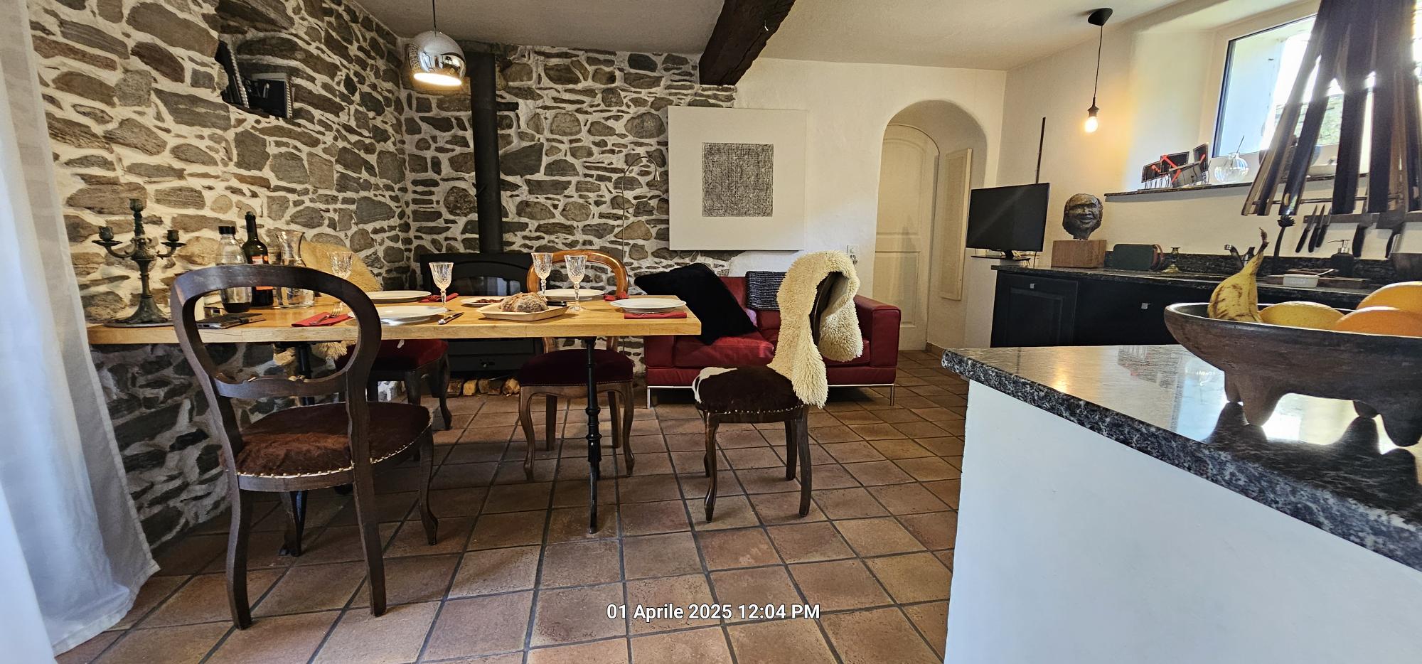 Rustikaler Essbereich mit sichtbarem Naturstein und Kamin