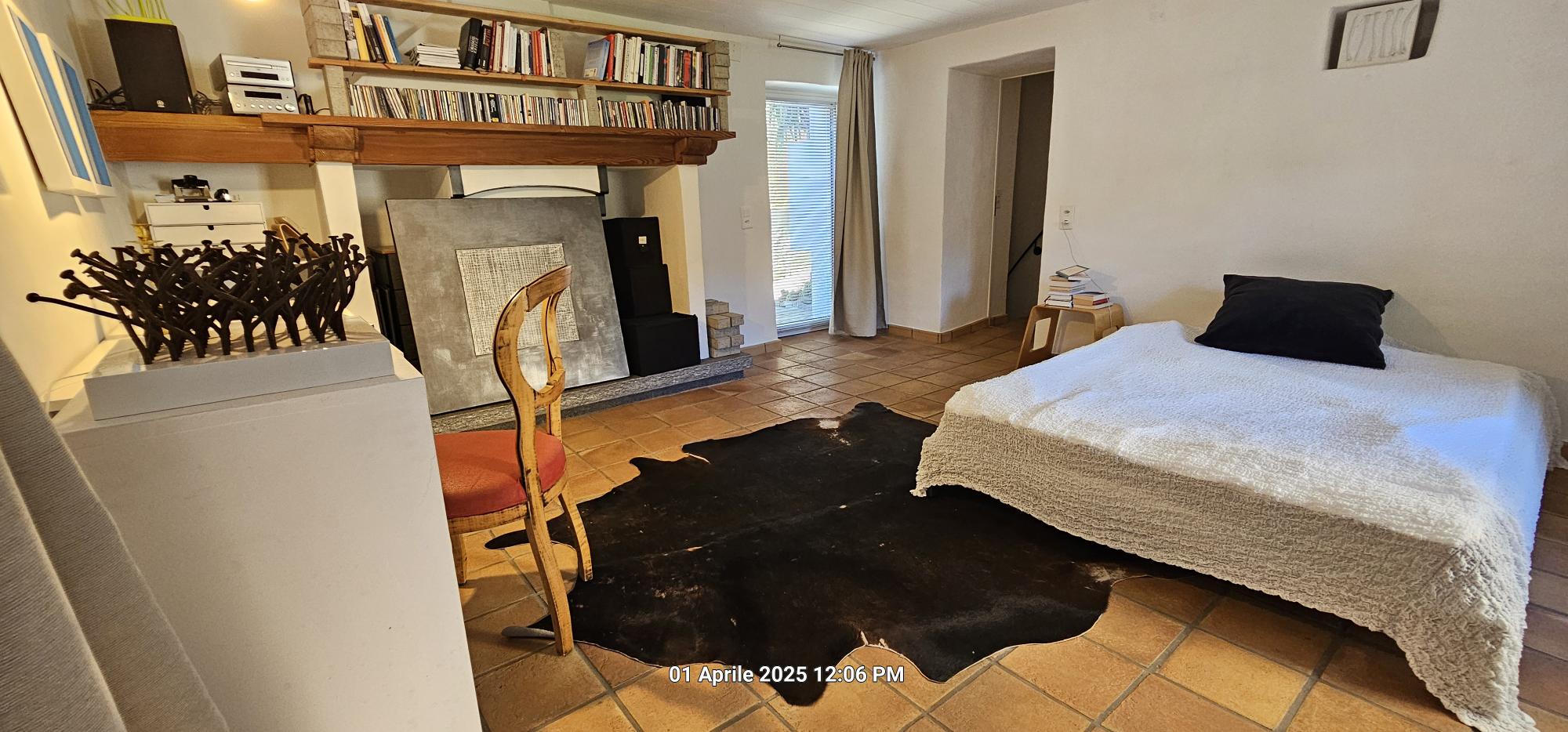 Gemütliches Schlafzimmer mit Kamin und rustikalem Boden