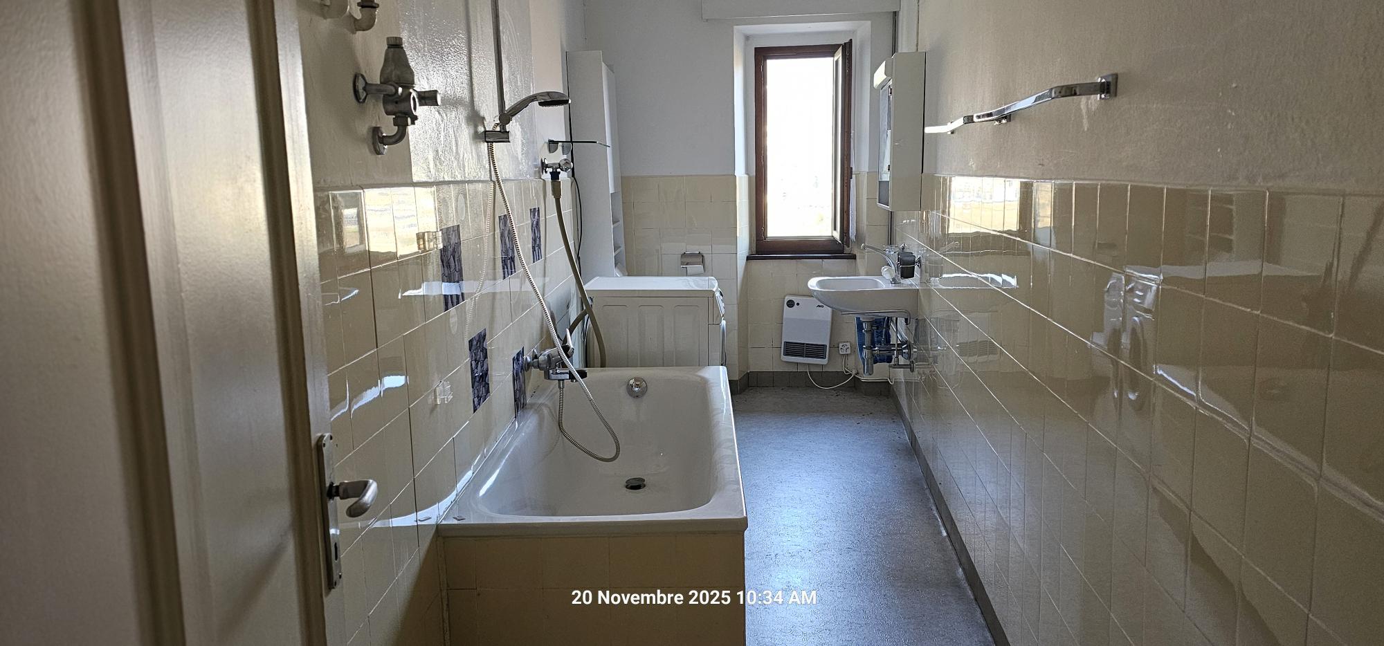 Schmaler Badezimmerraum mit Wanne