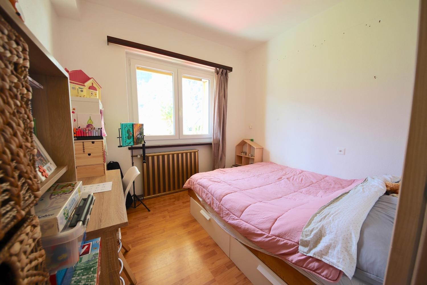Kinderzimmer mit Einzelbett und Arbeitsbereich