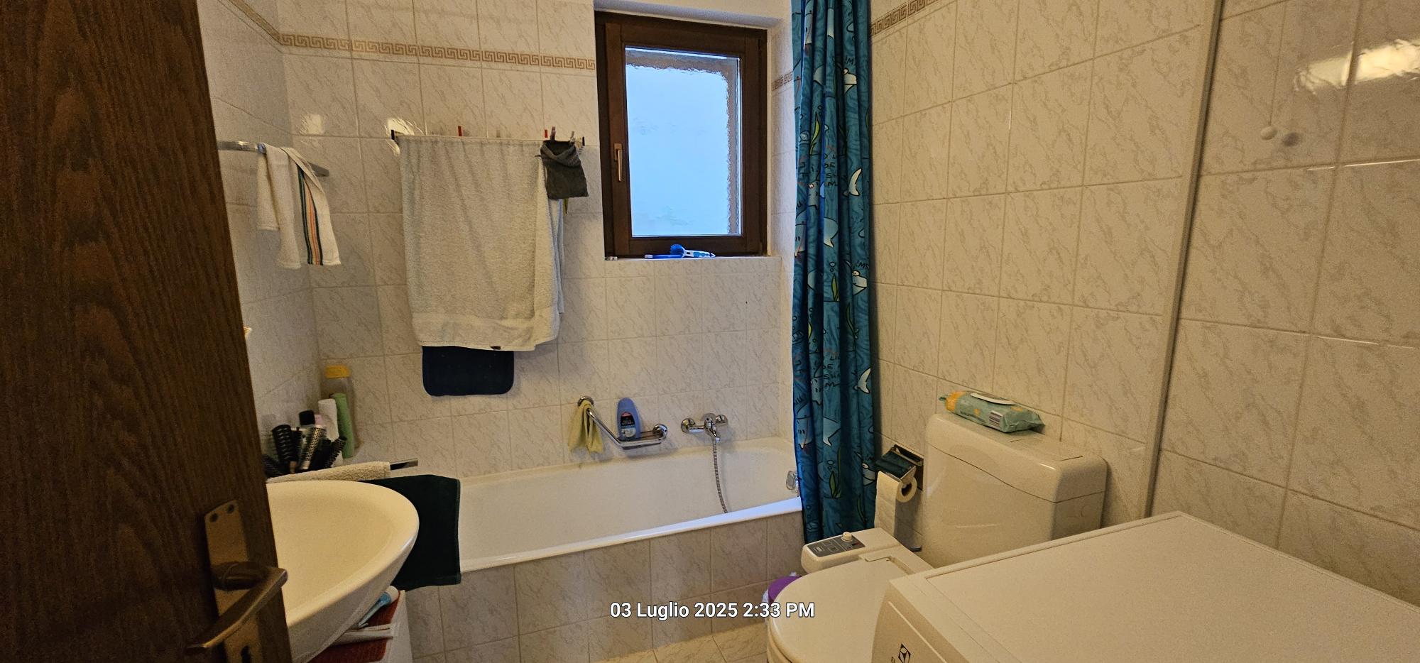 Badezimmer mit Badewanne und WC