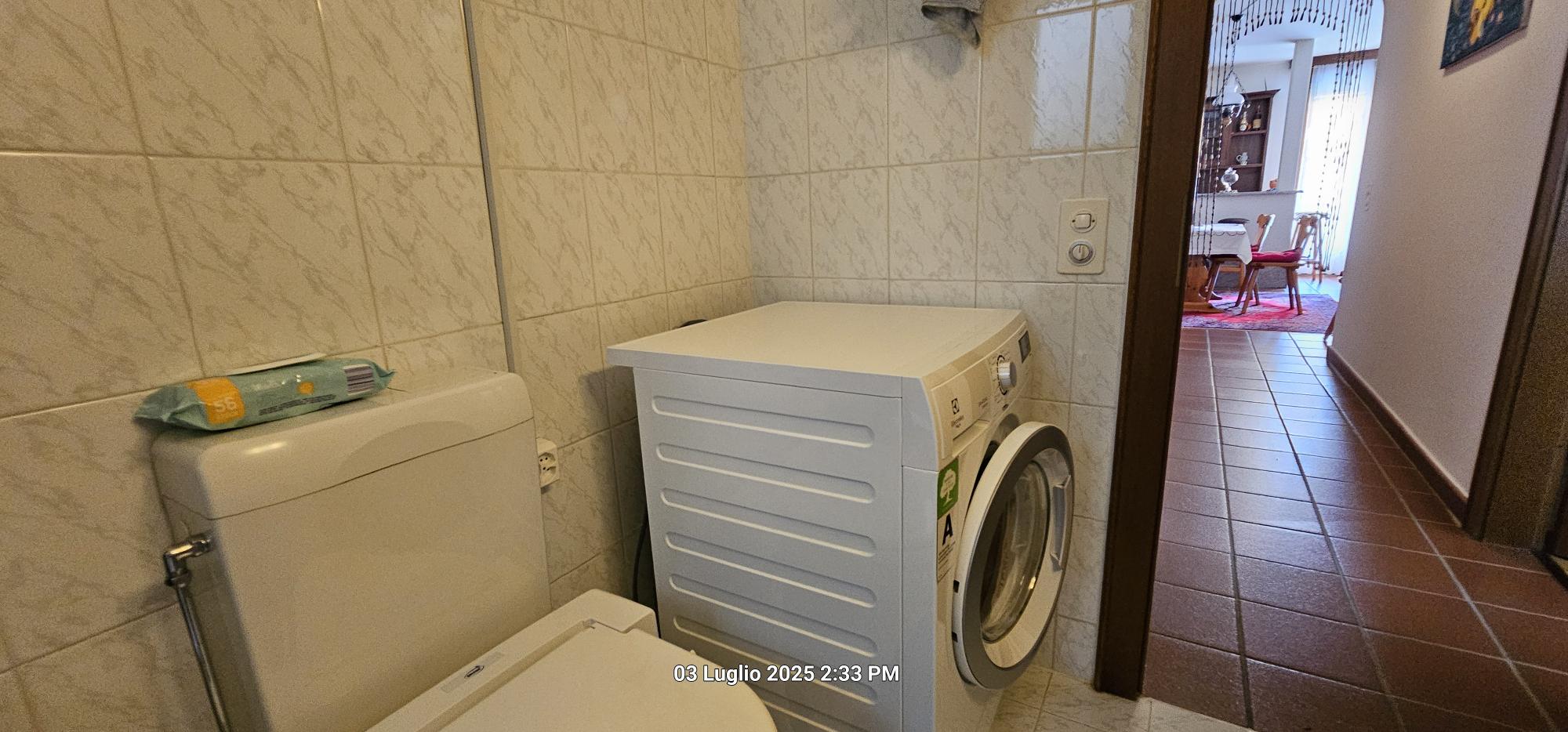 Hauswirtschaftsraum mit Waschmaschine und WC
