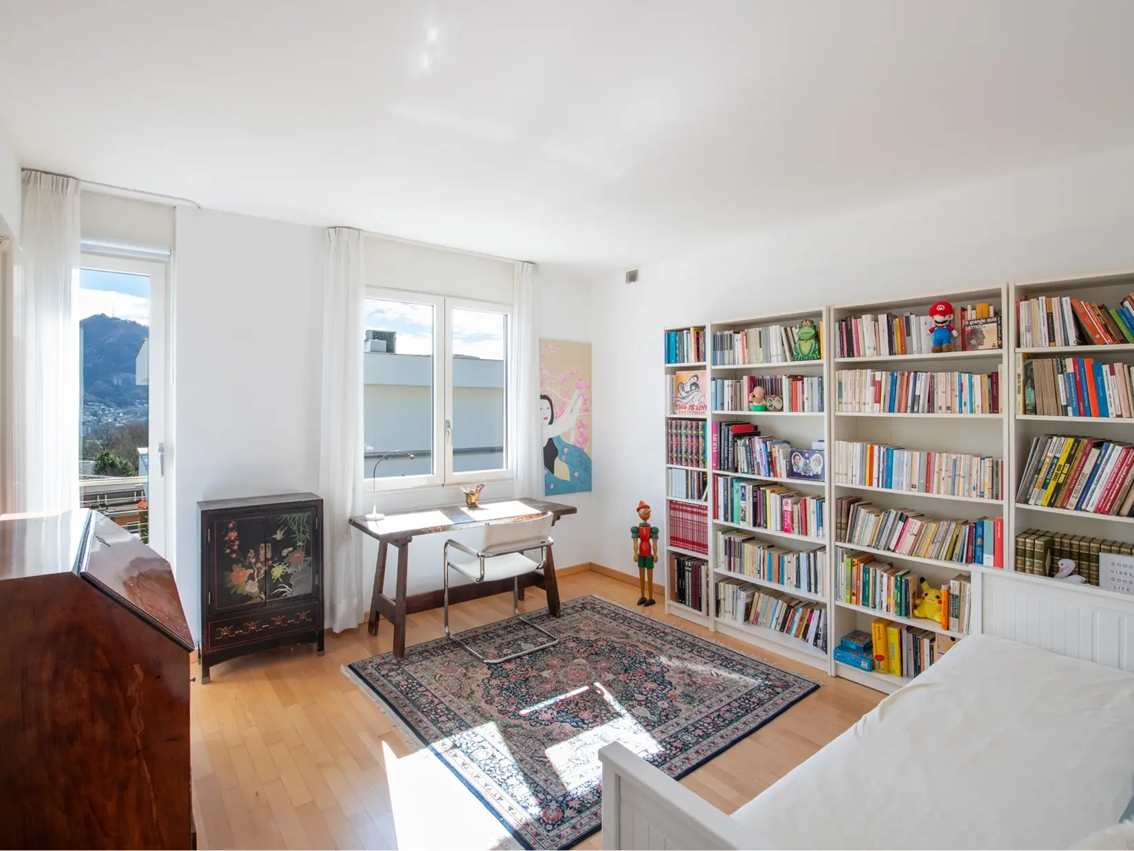 Helles Arbeitszimmer mit Bücherregalen und Ausblick