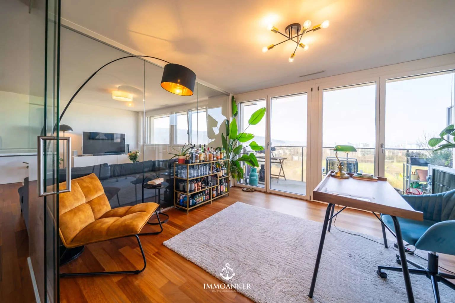 Helles Wohn- und Arbeitszimmer mit Balkonblick