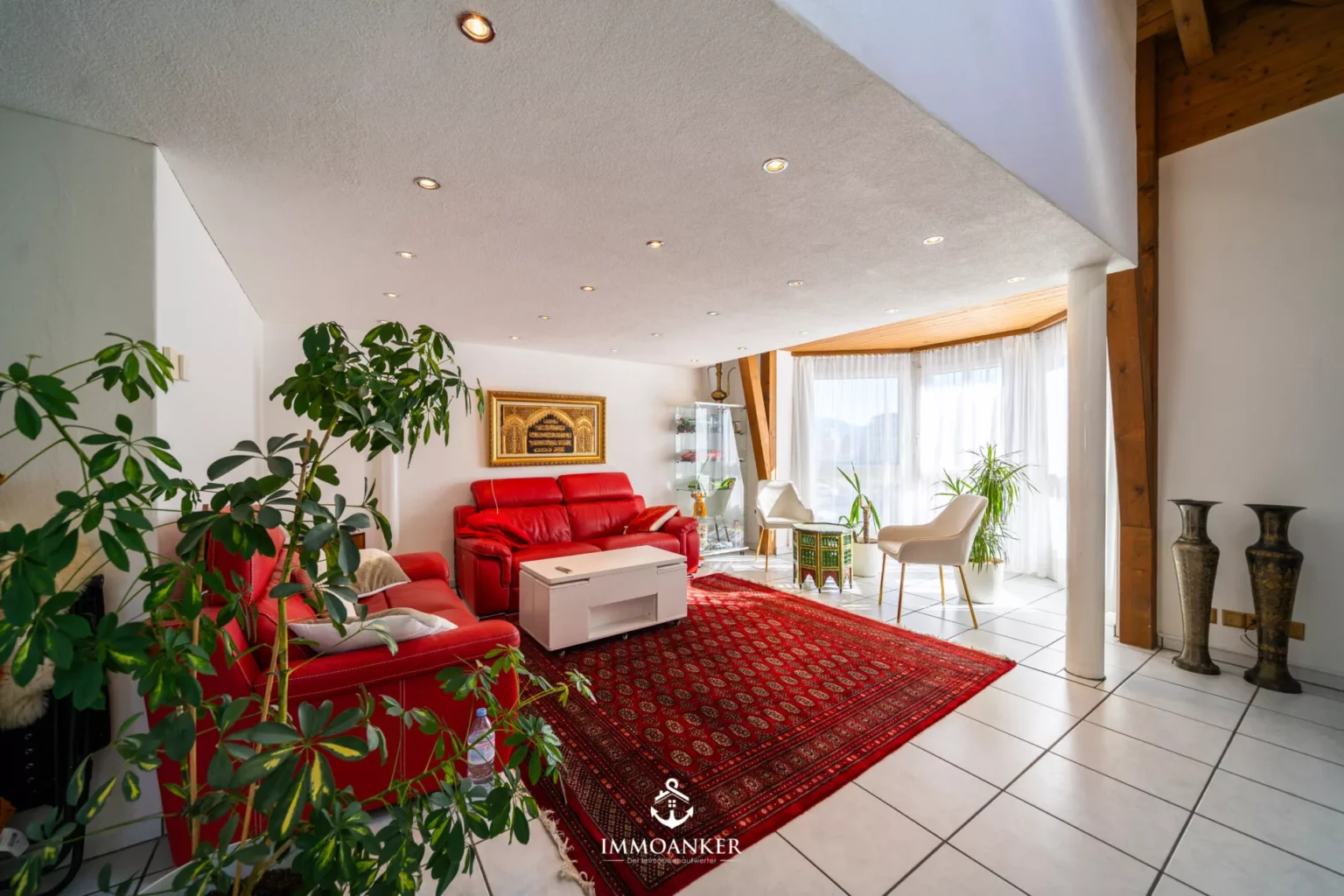 Heller Wohnraum mit rotem Sofa und großem Teppich