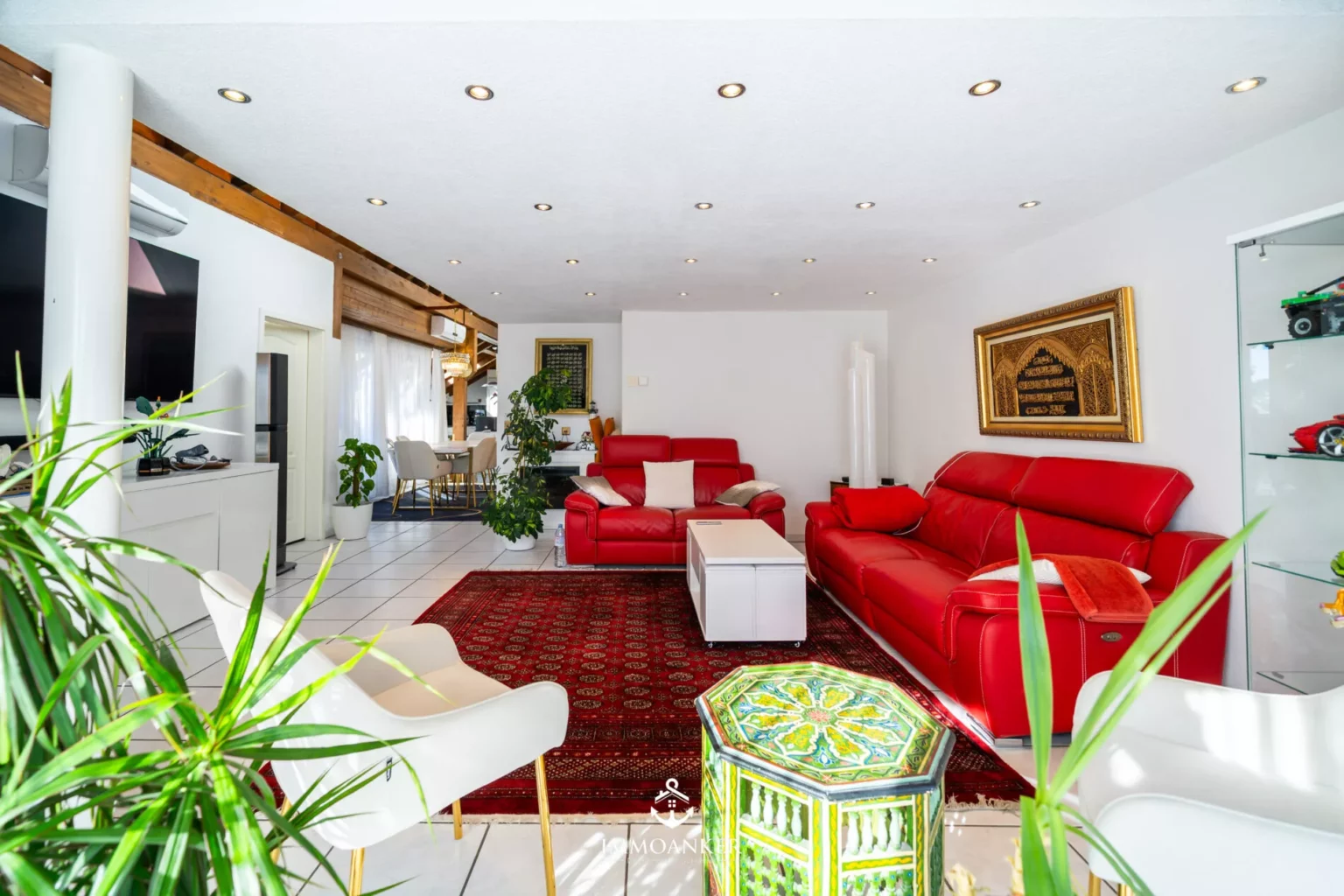 Helles Wohnzimmer mit rotem Sofa und orientalischem Dekor